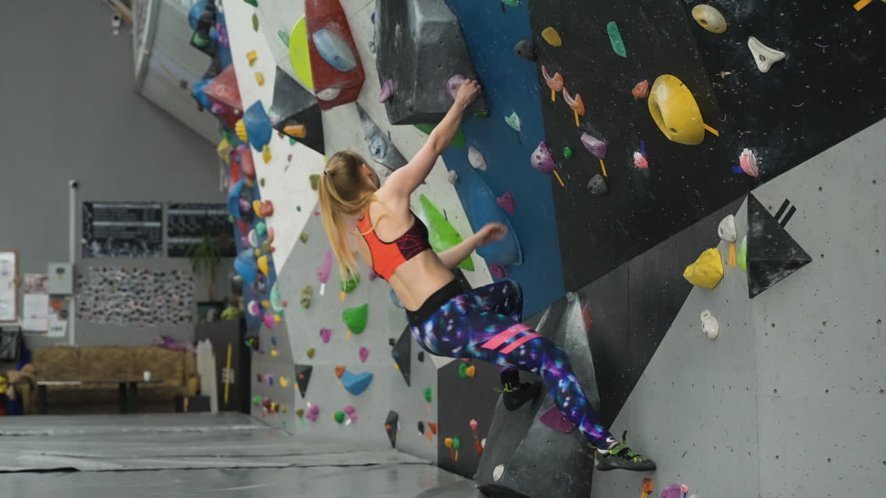 persona en un centro de escalada en la pared