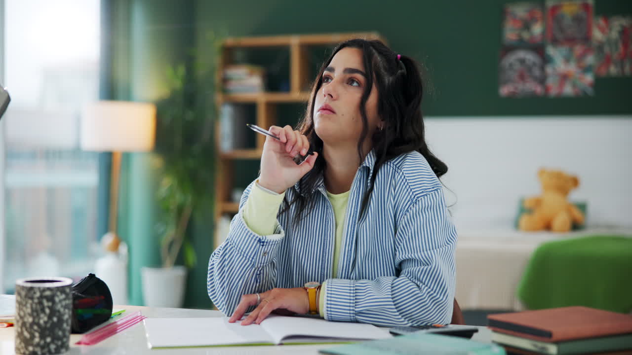 Woman thinking while studying at her desk