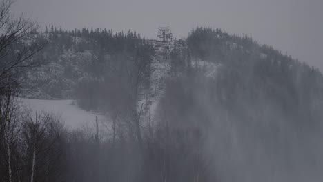 empty chairlifts at mount orford national park in quebec, canada in winter with mist from snowmaking machines - wide shot, static