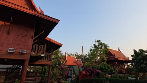 showcasing a thai house amidst a blooming garden