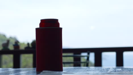 A red can sits on a balcony railing