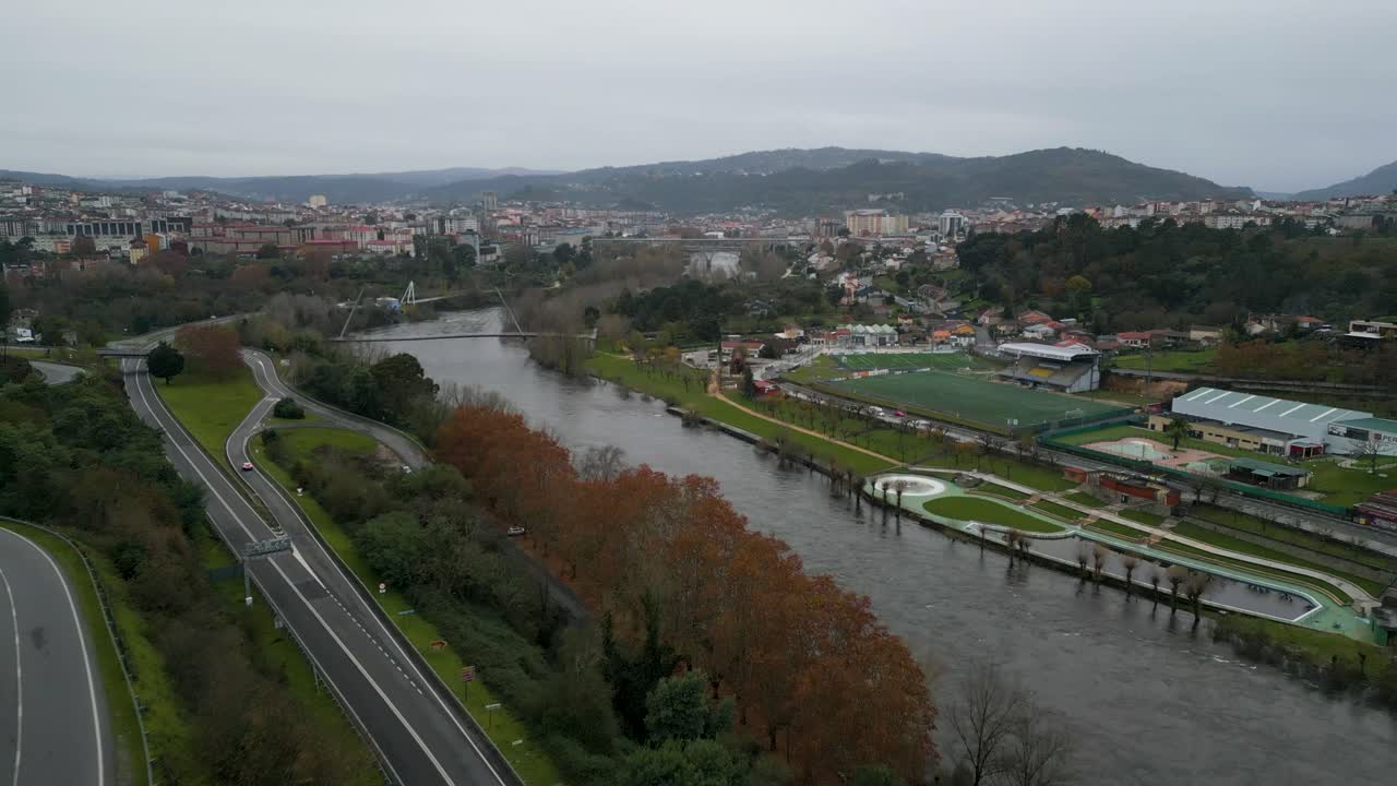 Oira and Mi&ntilde;o river with winding pedestrian bridge crossing water, Ourense Spain