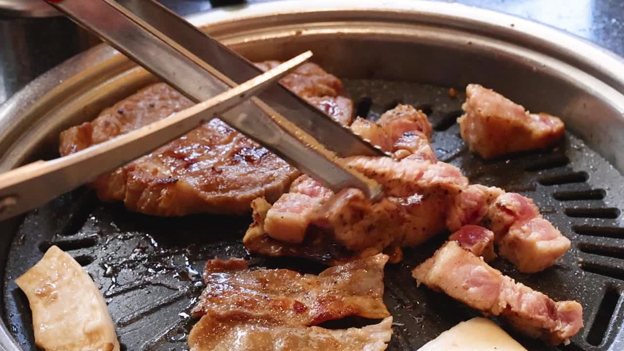 Gros plan sur des mains utilisant des ciseaux et des pinces pour couper de la viande grésillante sur un gril