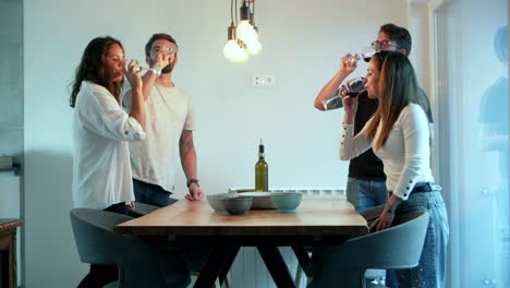 Amigos-Sonrientes-Animando-Con-Copas-De-Vino-Mientras-Están-De-Pie-Cerca-De-La-Mesa