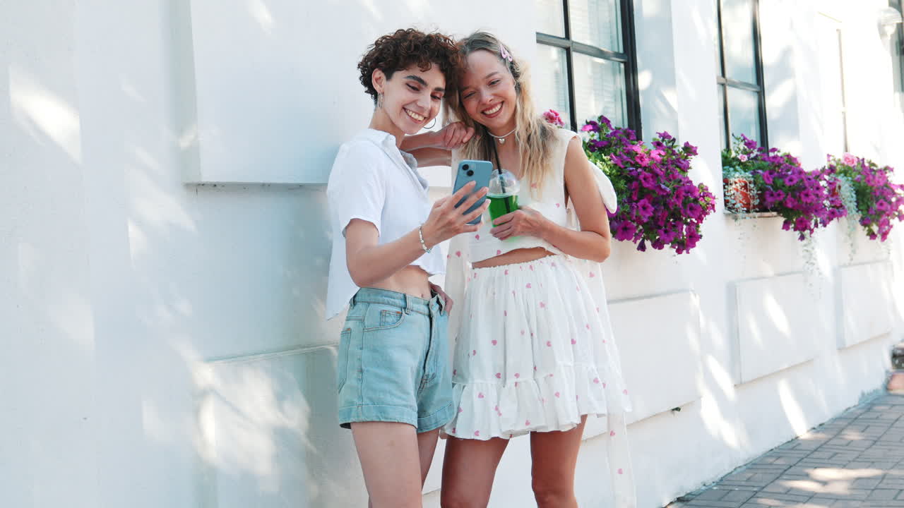 두 명의 여성 친구가 스마트폰을 보고 있습니다.