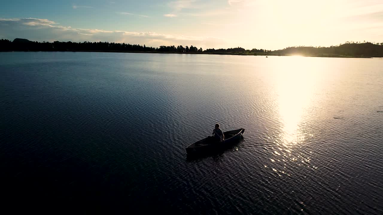 Bellissima alba in Colorado su un lago con la silhouette di una canoa contro il sole nascente