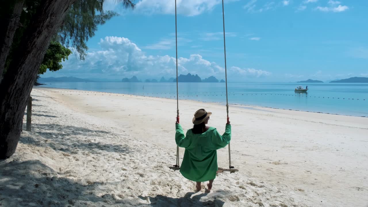 hombres y mujeres en un columpio en la playa