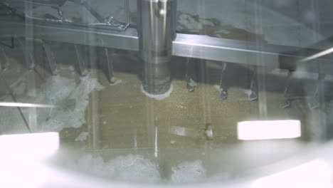 churning barley grain in brewery silo for beer production, wide