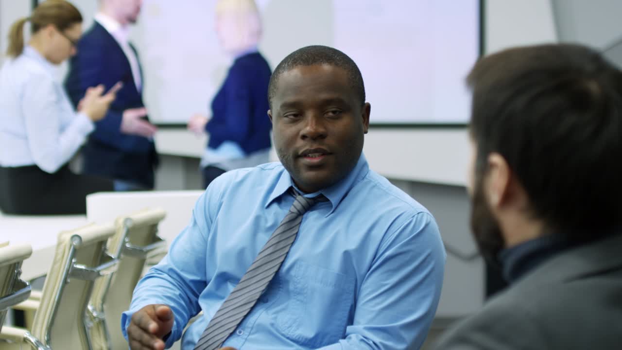 Black Businessman Talking with Colleague in Meeting Room
