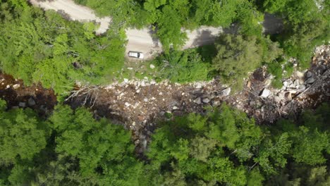 Aerial-top-down-flyover-road-near-river-in-Vermont,-USA