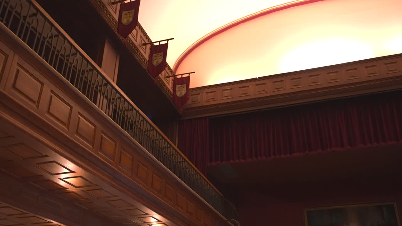 Ornate wooden beams and ceiling in old interior hallway with banners.