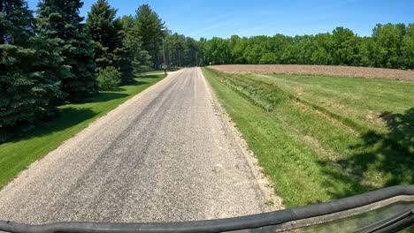 POV---driving-past-newly-planted-fields,-farm-yards,-timbers-and-country-homes