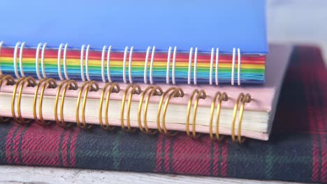 stack of colorful notebooks on a wooden table