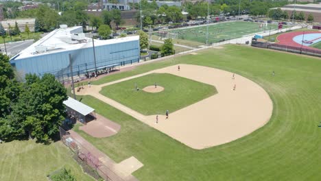 baseball player gets a base hit to center field during summer pickup game - drone view