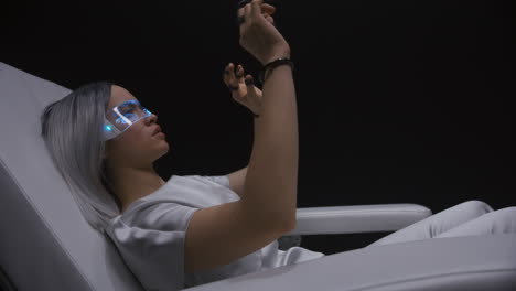 una mujer cyberpunk disfrutando de una silla interactiva en primer plano. el jugador toca el metaverso.
