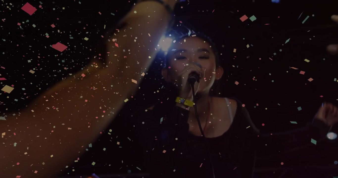 Concert singer singing intro backlit sparking confetti as fans reaching and leaning engaging them