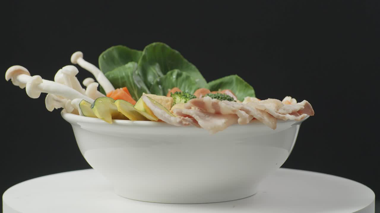 검은색 배경의 부에서  테이블 위에 회전하는 샤부 재료의 그의 근접