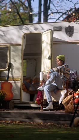 woman reading a book in a cozy autumn camping setting