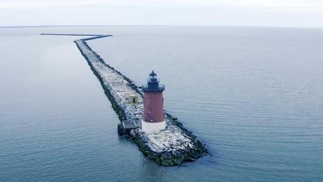 old red breakwater light house cape henlopen delaware united states on overcast spring day aerial circling shot