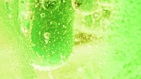 macro shot of big green bubbles floating and dripping in bright green water