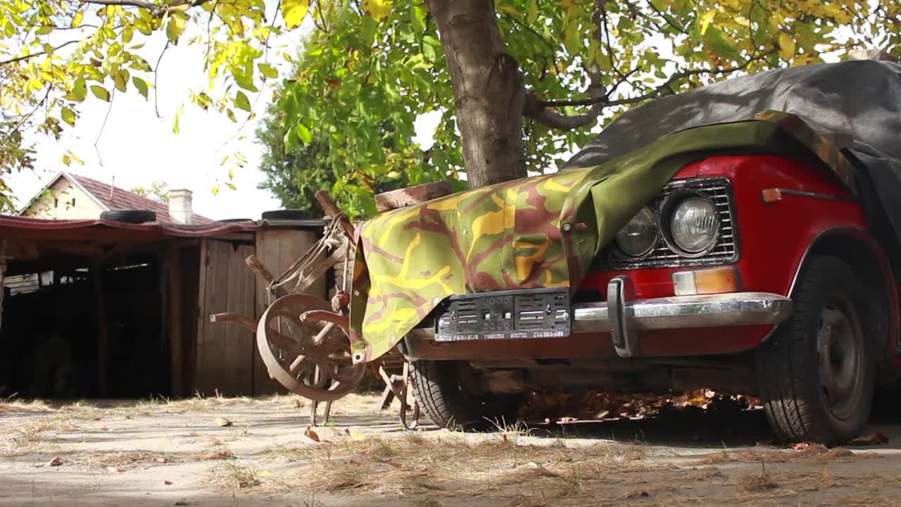 viejo coche rojo abandonado en la granja