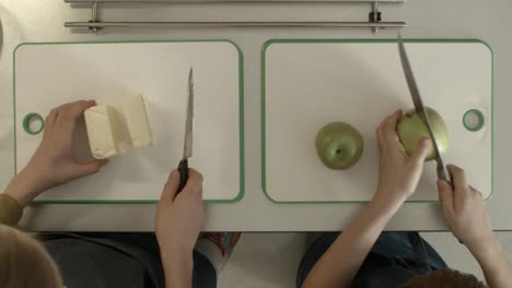 niños cortando mantequilla y manzana