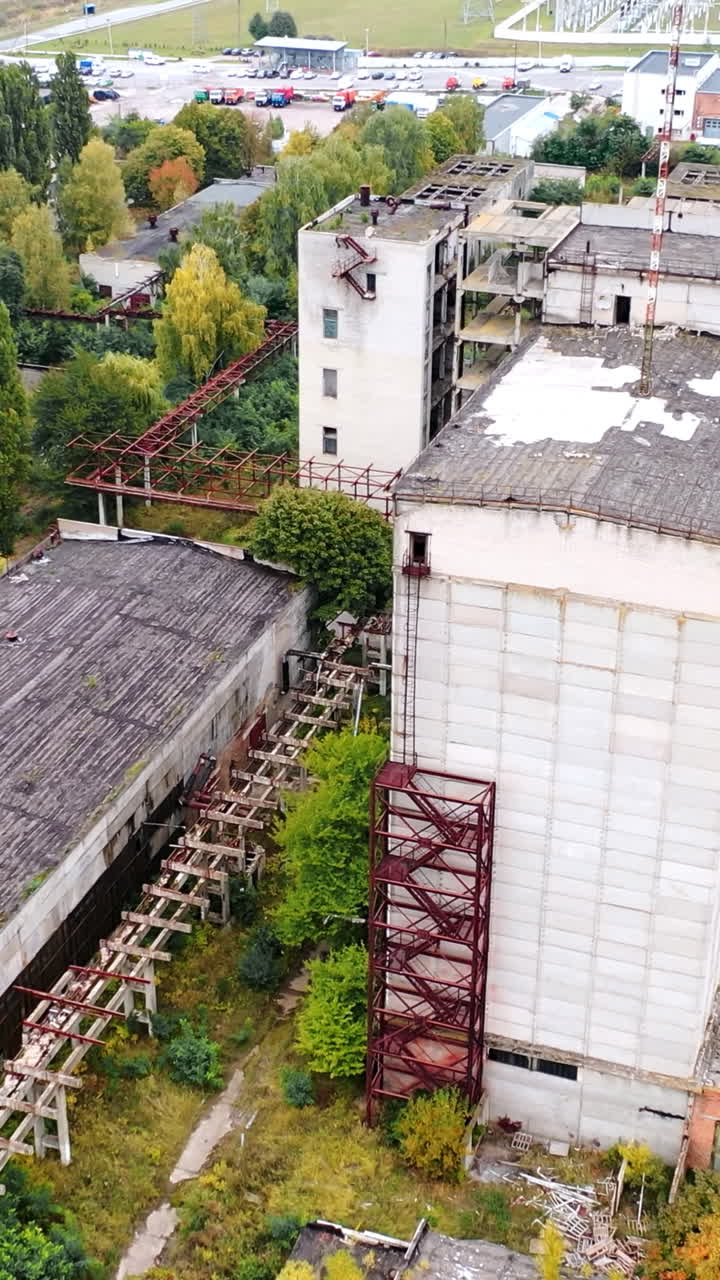 Empty factory caused by the world crisis. Abandoned buildings of industrial plant. Old brick buildings and warehouses. Camera rising.. Vertical video