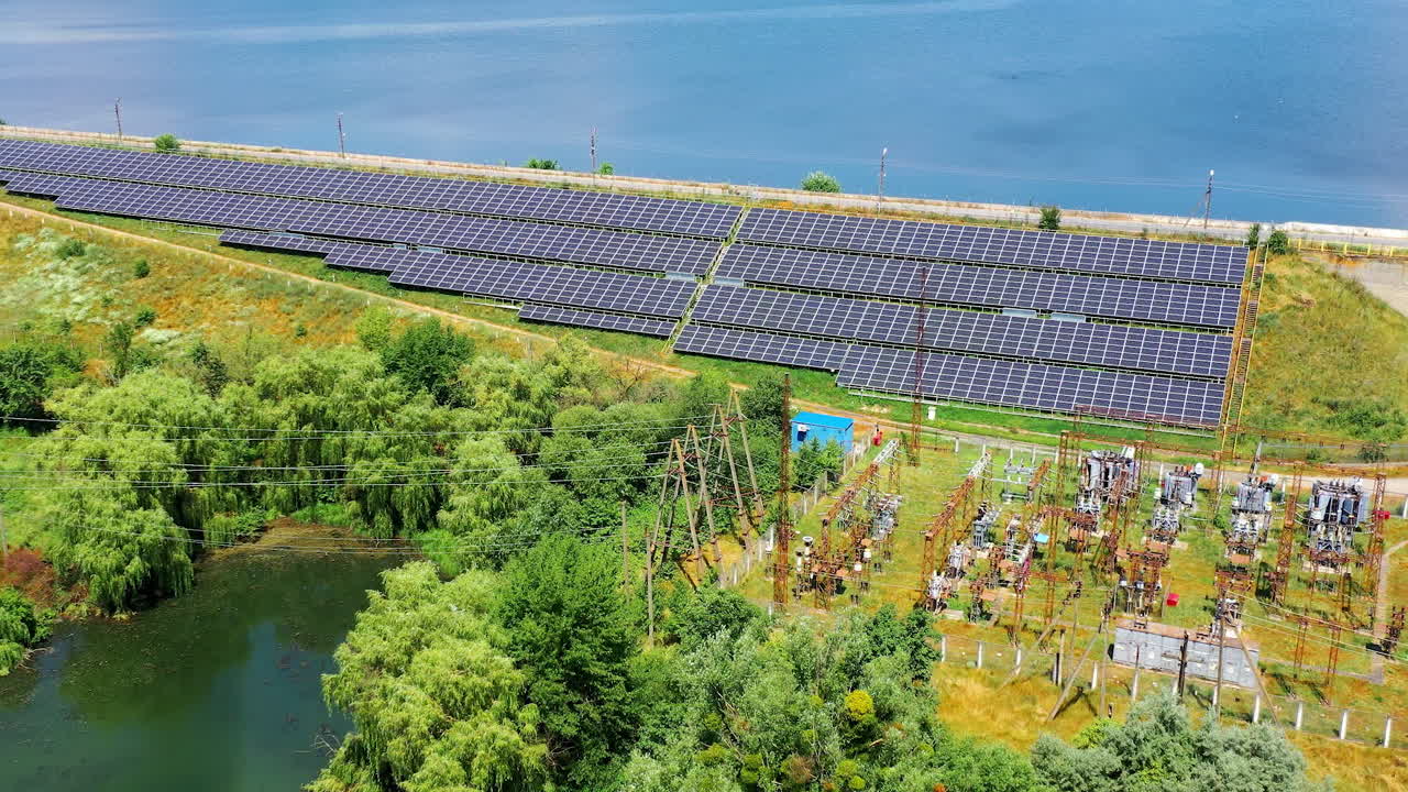 Solar energy farm on sea water background. Blue photovoltaic panels get sunny energy. Renewable source of green eco energy. Aerial view