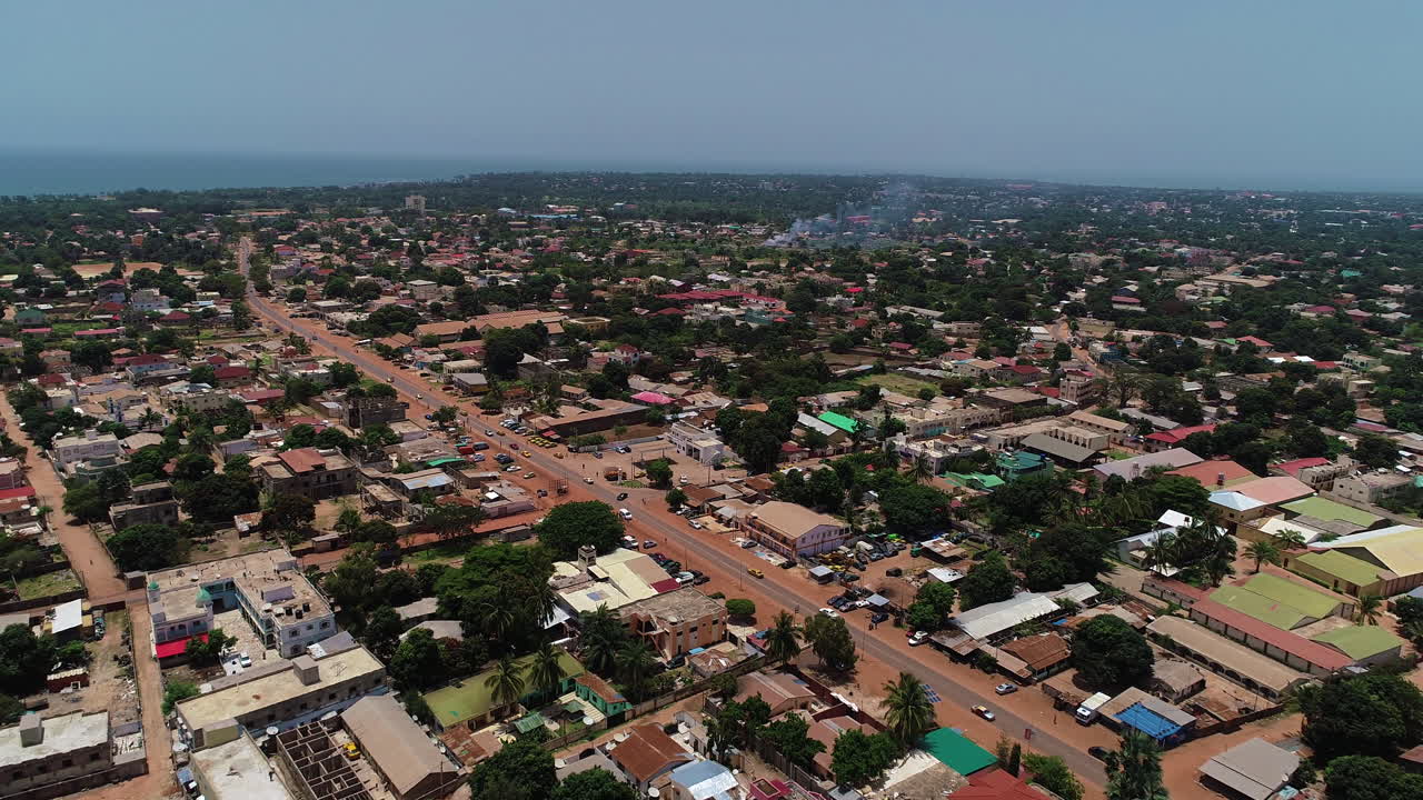 Voo aéreo em direção a uma estrada sem nome em Serrekunda, acima do campo de futebol de Manjai.