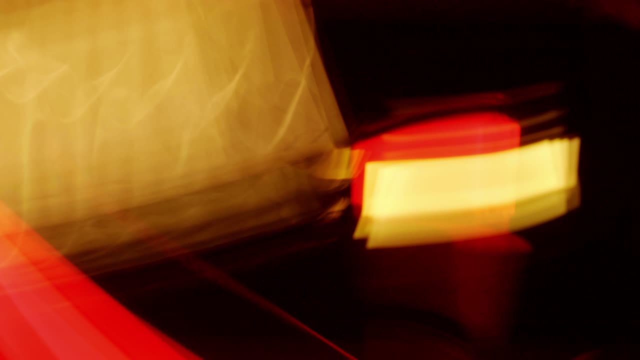 el movimiento borroso de la luz de rayas rojas y amarillas se mueve rápidamente sobre un fondo negro.