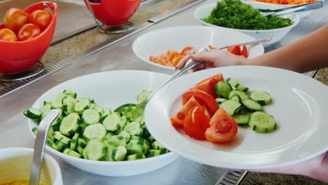 take the sliced cucumbers on the plate and watering sauce in the cafe with self-service