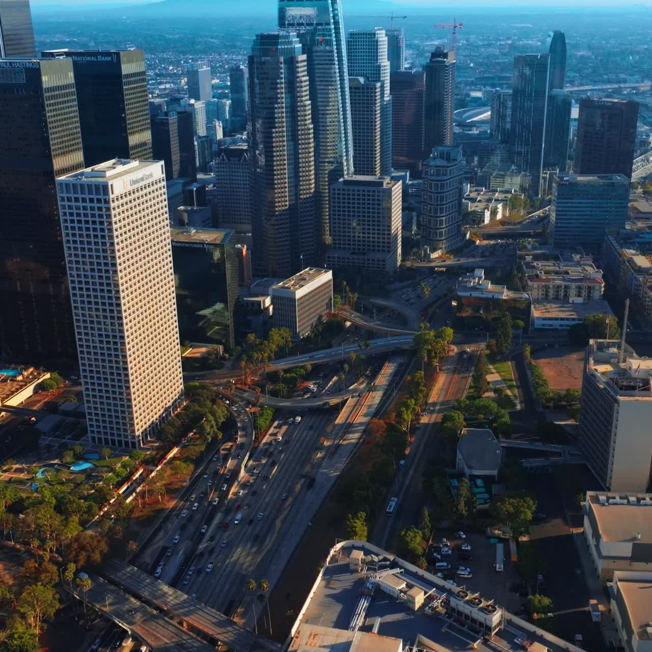 Sistemas rodoviários complexos e cruzamentos entre os deslumbrantes arranha-céus. Trânsito caótico no centro de Los Angeles. Vista aérea