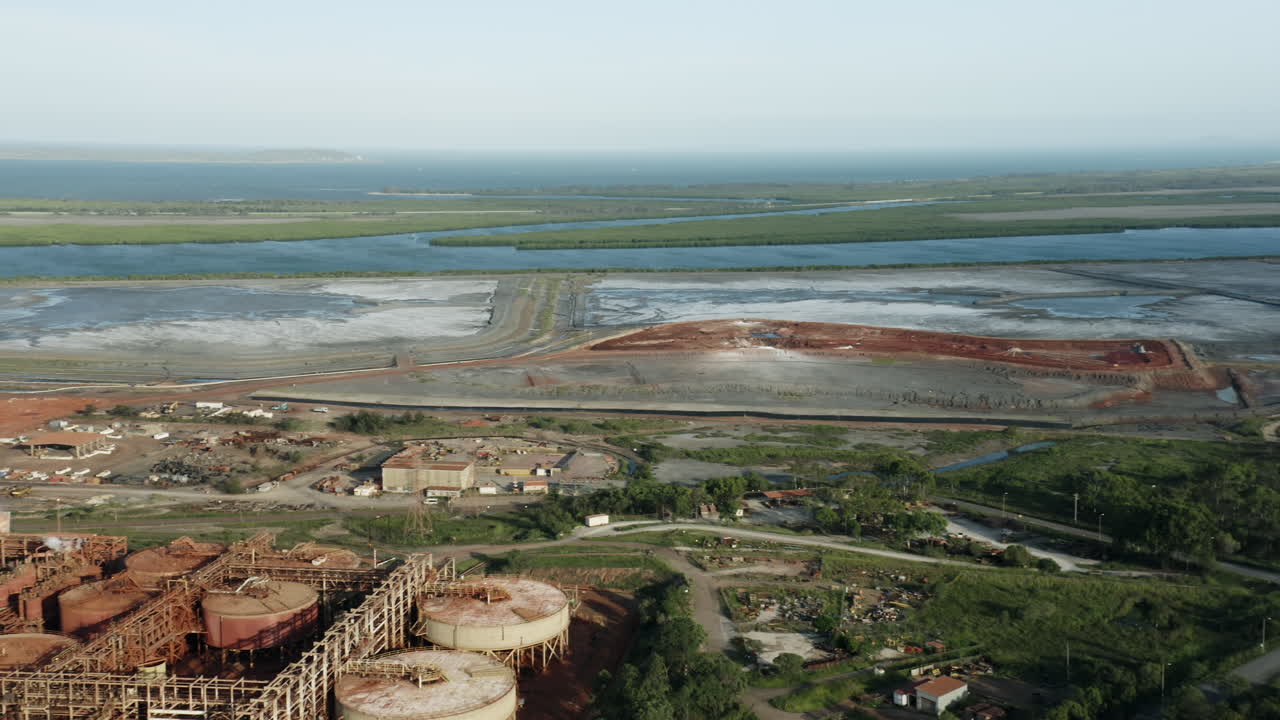 toma panorámica aérea de fábrica industrial, islas y océano en segundo plano durante la luz del sol