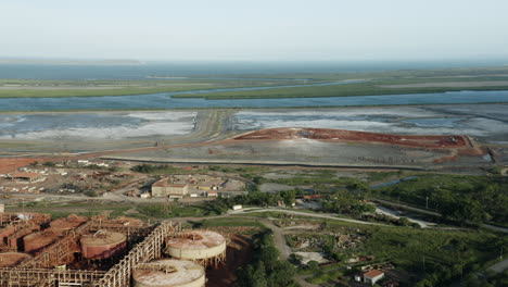 aerial panning shot of industrial factory,islands and ocean in background during sunlight