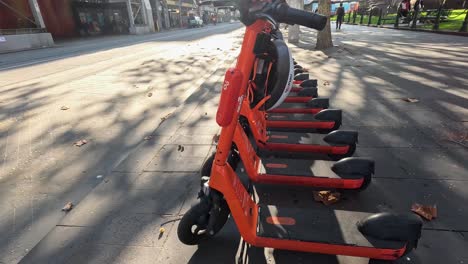 row of electric scooters on a sunny street