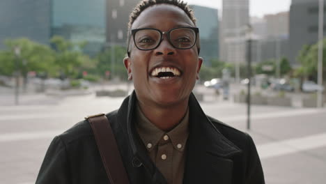 Primer-Plano-Retrato-De-Un-Joven-Afroamericano-De-Moda-Con-Gafas-Riéndose-Alegremente-De-La-Cámara-Disfrutando-Del-Estilo-De-Vida-Urbano-En-La-Ciudad