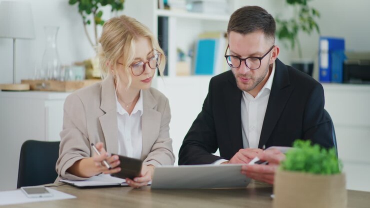 Business Meeting Discussing Project and Counting on Calculator