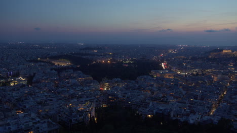 Dusk-settles-over-Athens,-highlighting-city-lights-and-landmarks