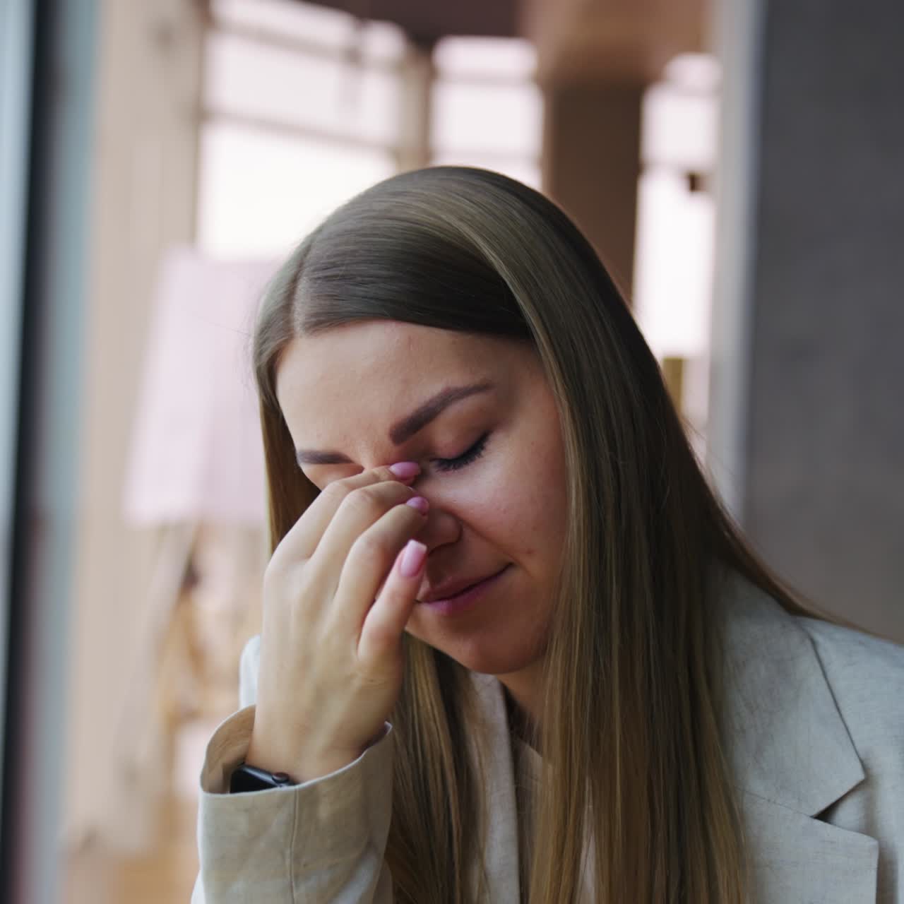 Giovane donna bionda che si toglie gli occhiali. Ragazza con capelli lunghi stanca che si tocca la fronte per rilassarsi. Primo piano