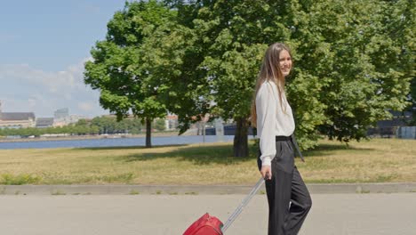 happy businesswoman arrived to riga city, walking with luggage