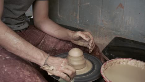 the potter makes a jug of clay. ceramist. a man makes a vase on a potter's wheel