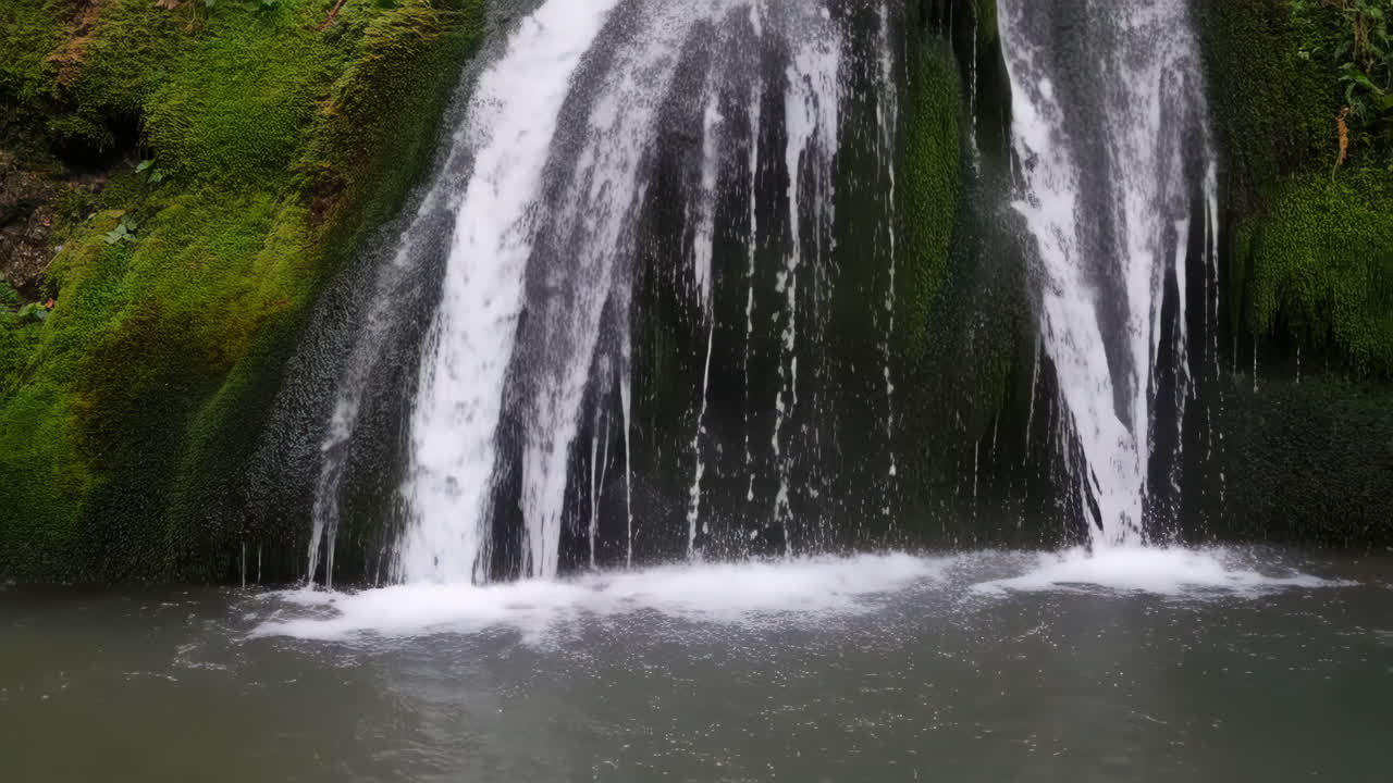 Tranquil Waterfall Cascading Over Mossy Rocks