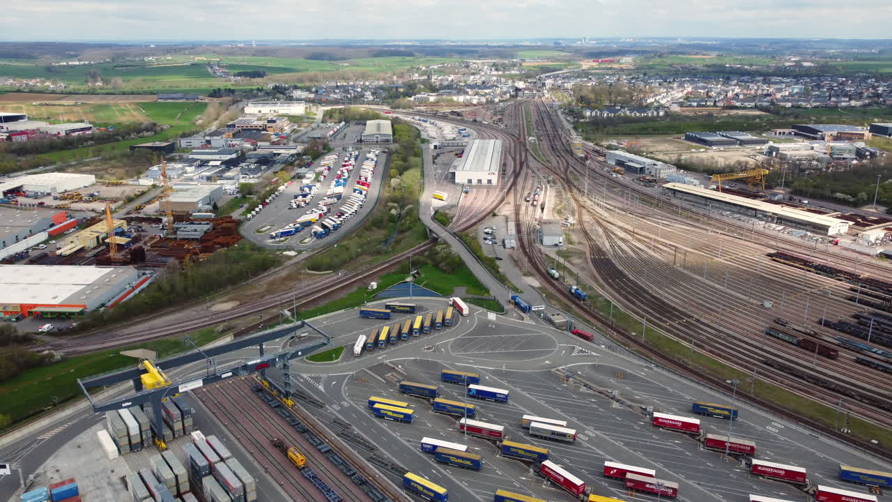 Aerial View of a Transportation Hub with Railroad, Trucks, and Containers