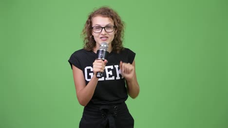 happy young beautiful nerd woman presenting with microphone