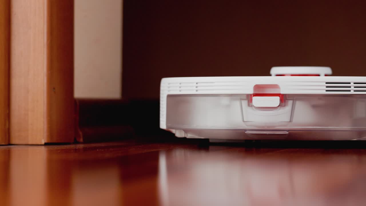 Smart Robot Vacuum Cleaner with lidar on wood floor. Robot vacuum cleaner performs automatic cleaning of the apartment. 4K slow motion 100 fps, ProRes 422, 10 bit