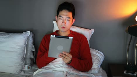 man using digital tablet on bed 4k