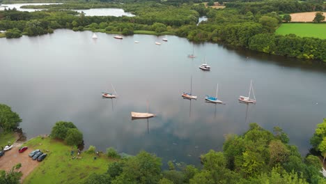 picturesque wroxham bay in norwich with lots of boats on the water and the reflection of the sky