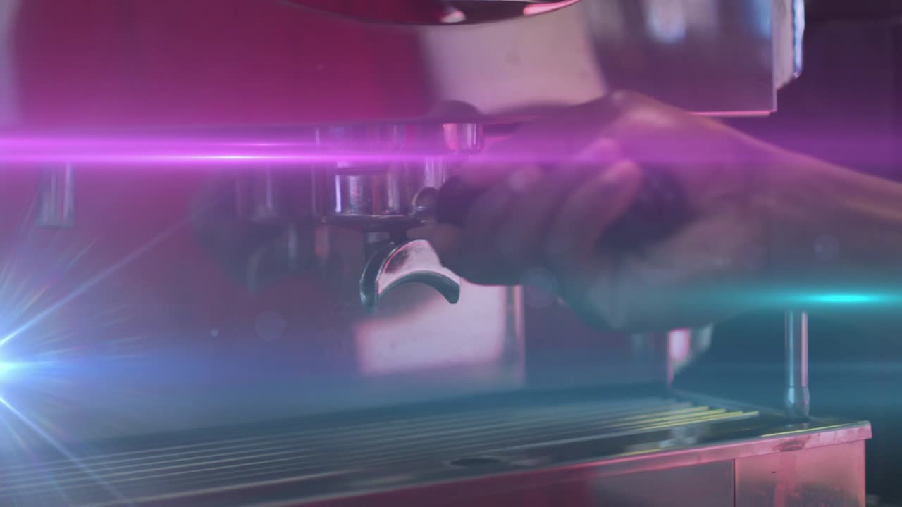 Barista hand inserting portafilter into head while twisting clockwise with neon flares in cafe