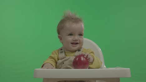 happy baby having fun and playing with apple.