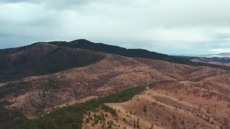 Aerial-flyover-shot-of-a-temperate-mountain-range-on-a-cloudy-day